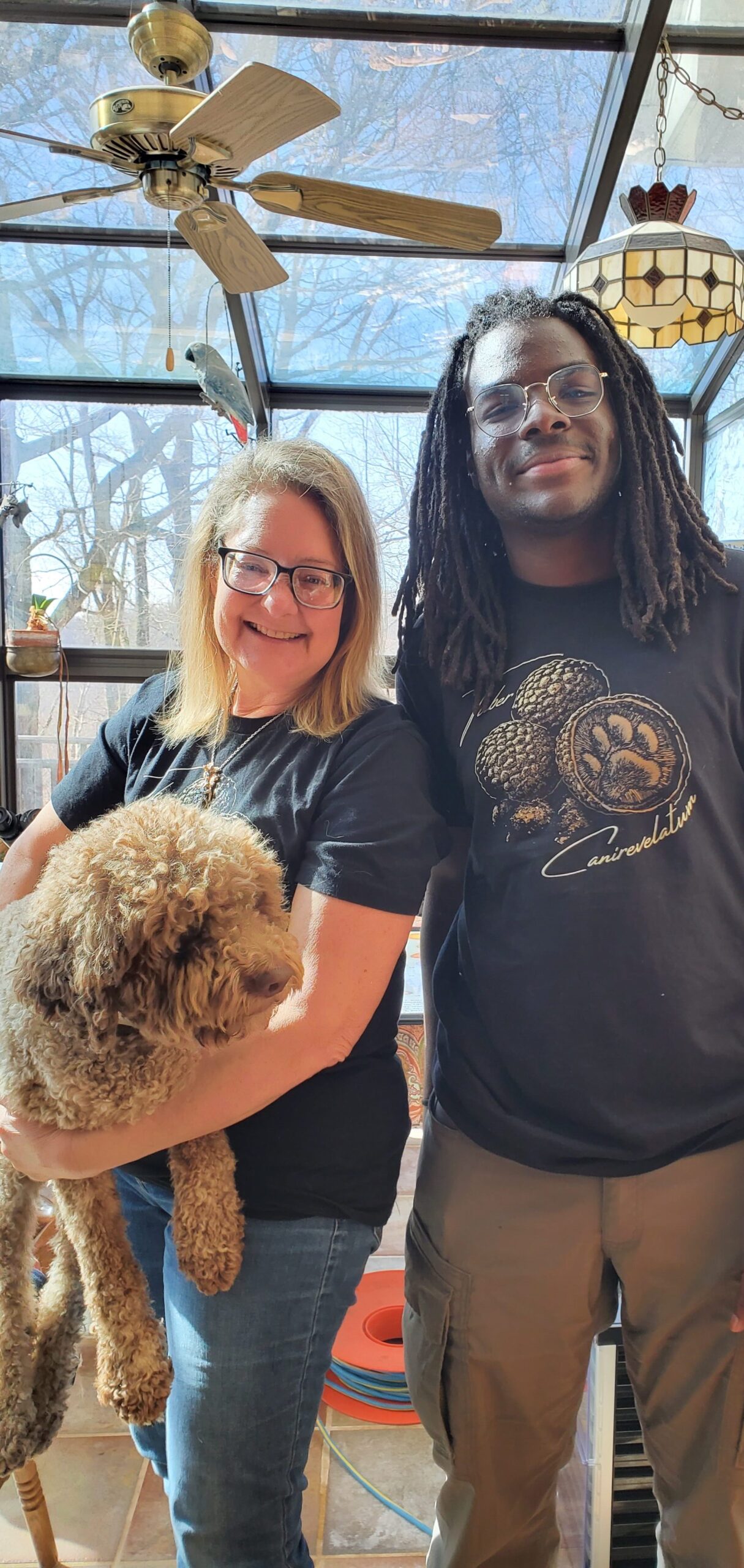 Alassane Sow and Margaret Townsend with Luca from NewTown Truffiere, wearing tee-shirts celebrating truffle hunting dog, Monza, and her find, the T. canirevelatum (meaning dog found).